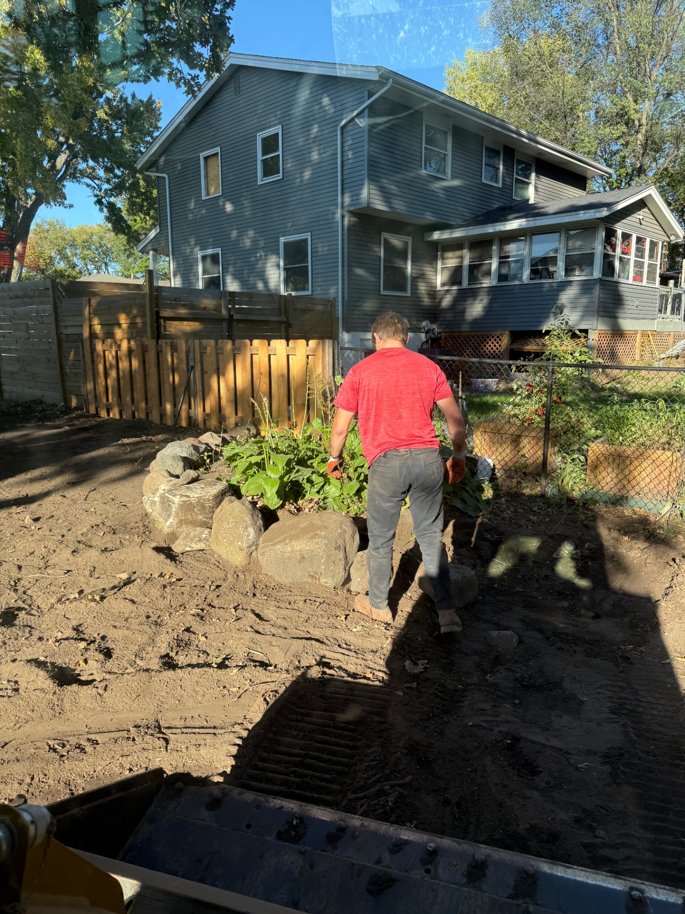 Crew hand-finishing the stone-edged planting bed in the regraded backyard at Knob Hill, Burnsville, MN