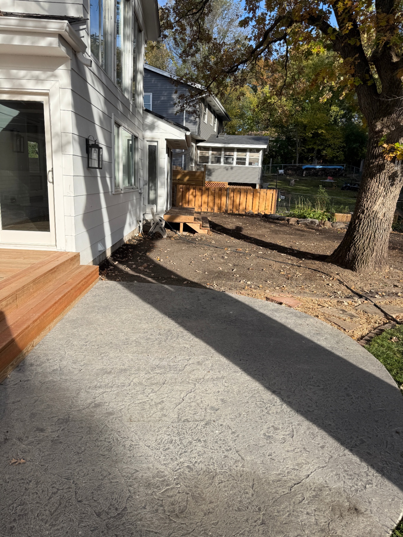 Finished texture-mat stamped concrete patio off the back of the Burnsville, MN home with adjoining wood deck steps