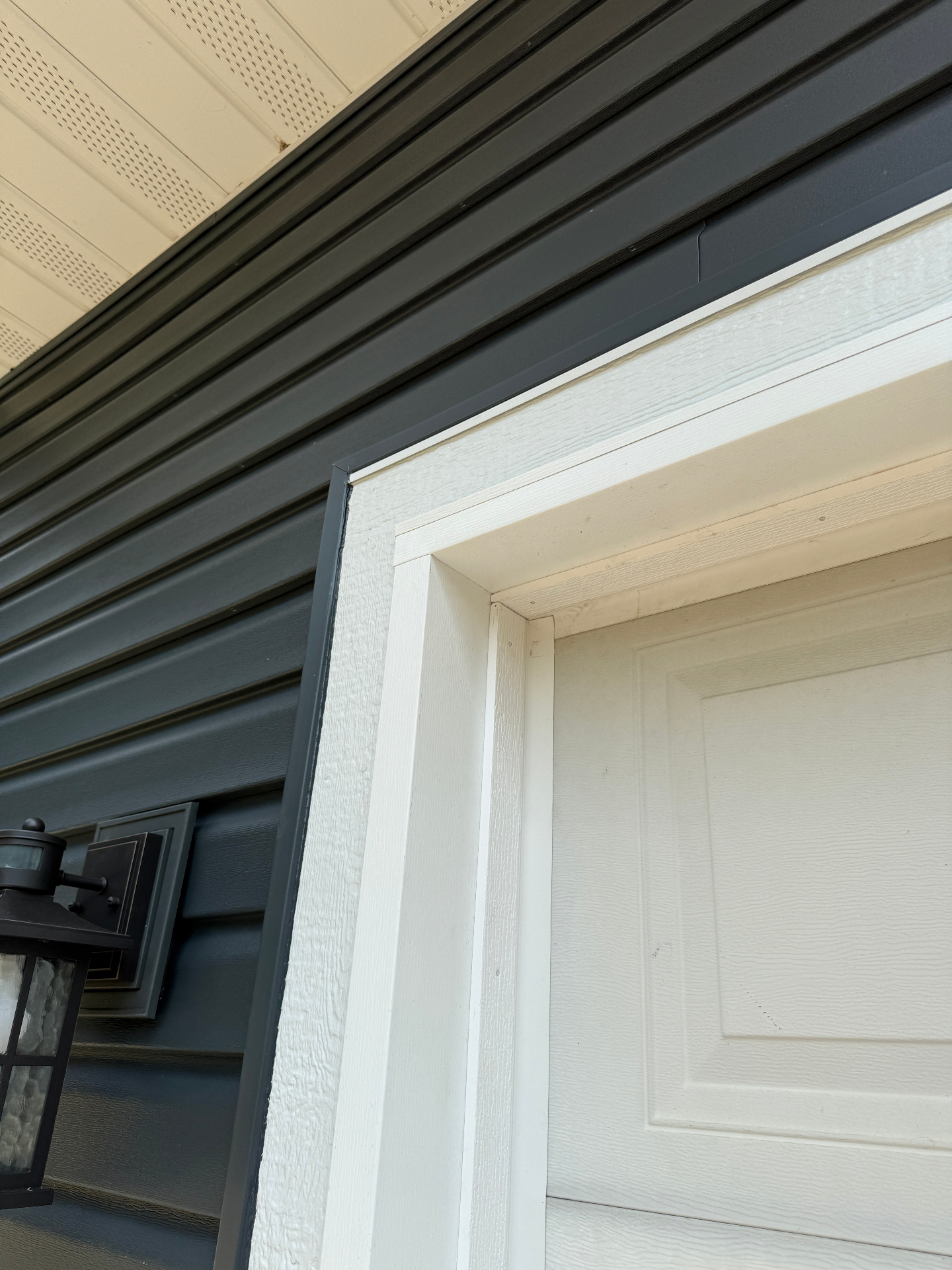 Close-up of the new siding, white window surround, and soffit detailing on the Elk River, MN home