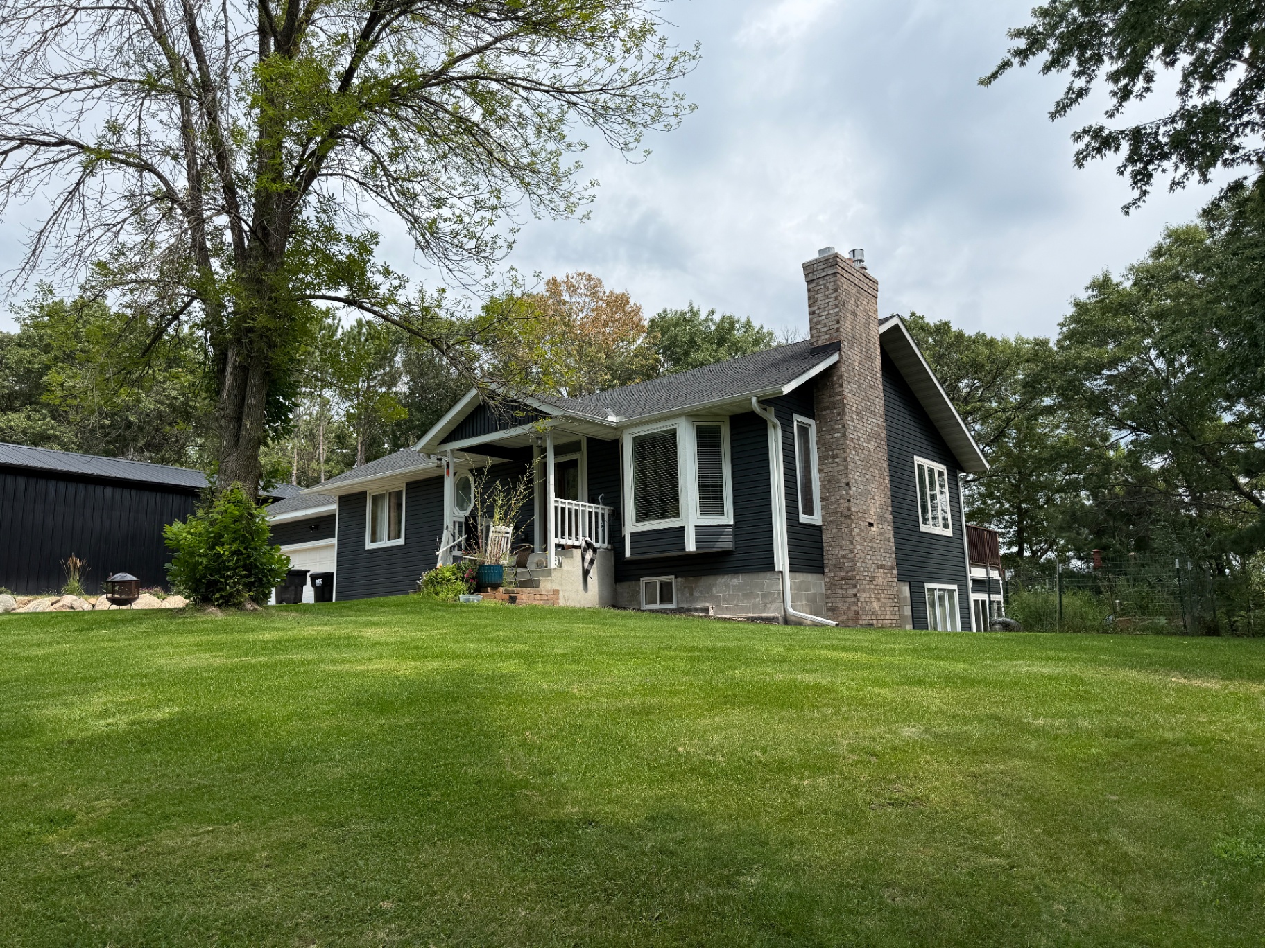 Elk River, MN front entry after the roofing and siding replacement, with white porch trim and the Charcoal shingle roof
