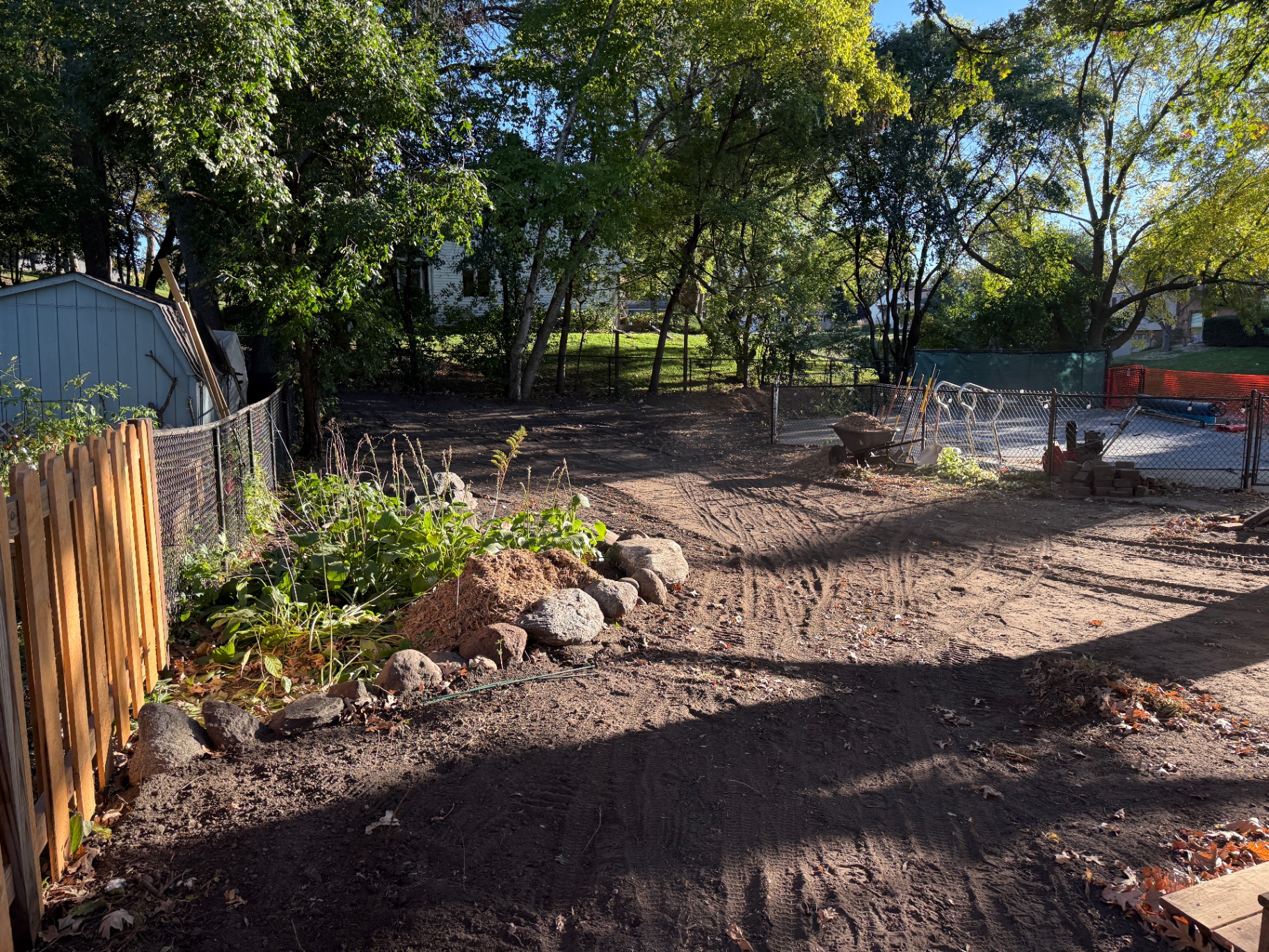 Backyard cleared of brush and debris with regraded soil and stone planting bed at the Knob Hill home in Burnsville, MN