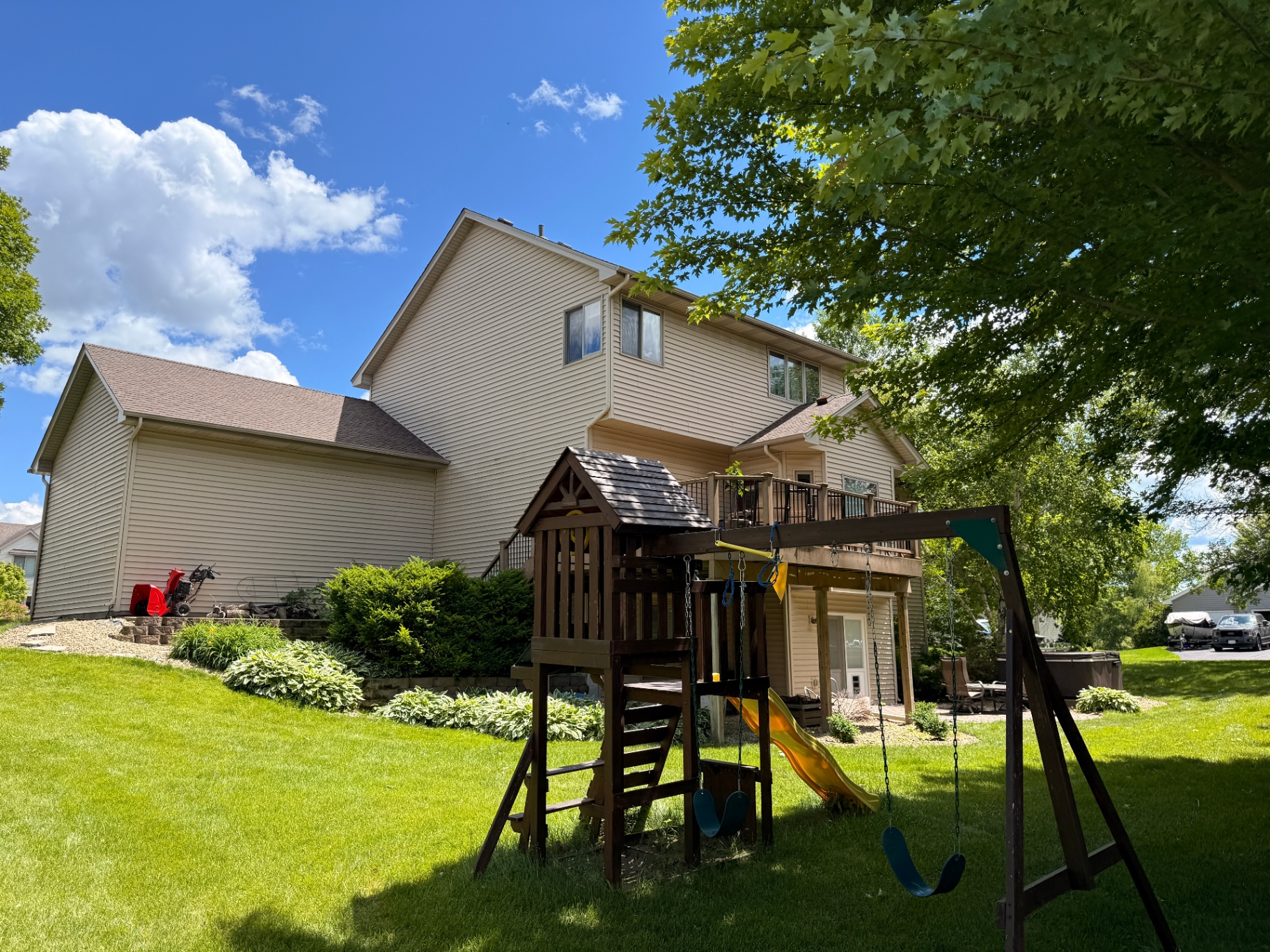 Backyard view of the finished storm-damage roof, gutter, and custom fascia replacement in Rogers, MN