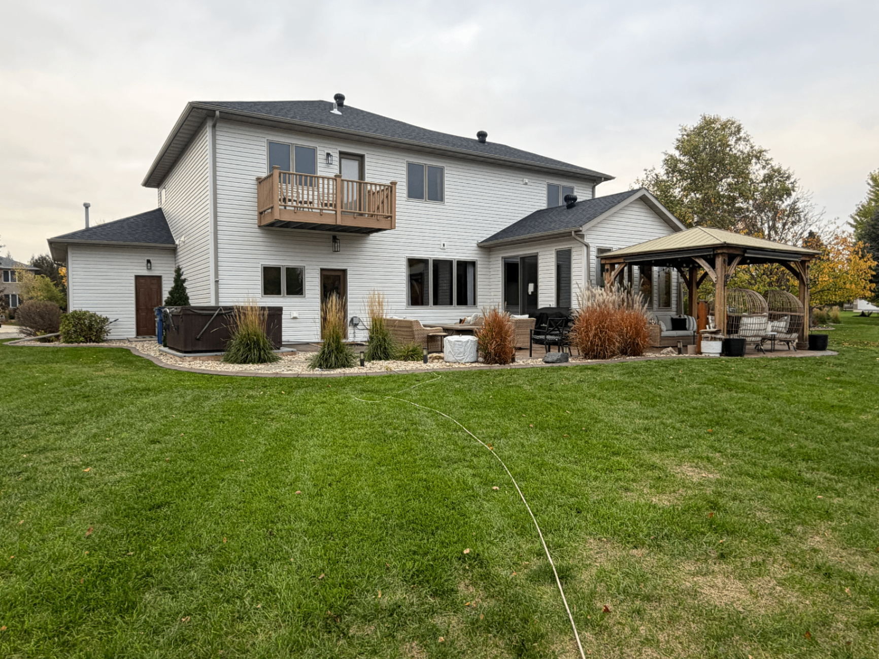 Rear elevation of a Moorhead, MN home with new light Linen Mastic Carvedwood dutch lap vinyl siding after an insurance-covered full siding replacement