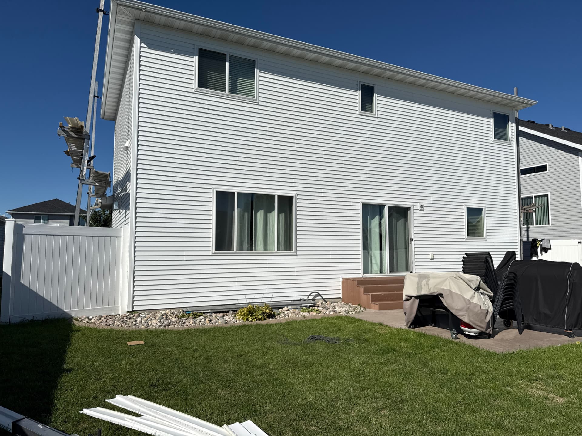 Rear elevation of Moorhead home with new white dutch lap vinyl siding after an insurance-covered full siding replacement