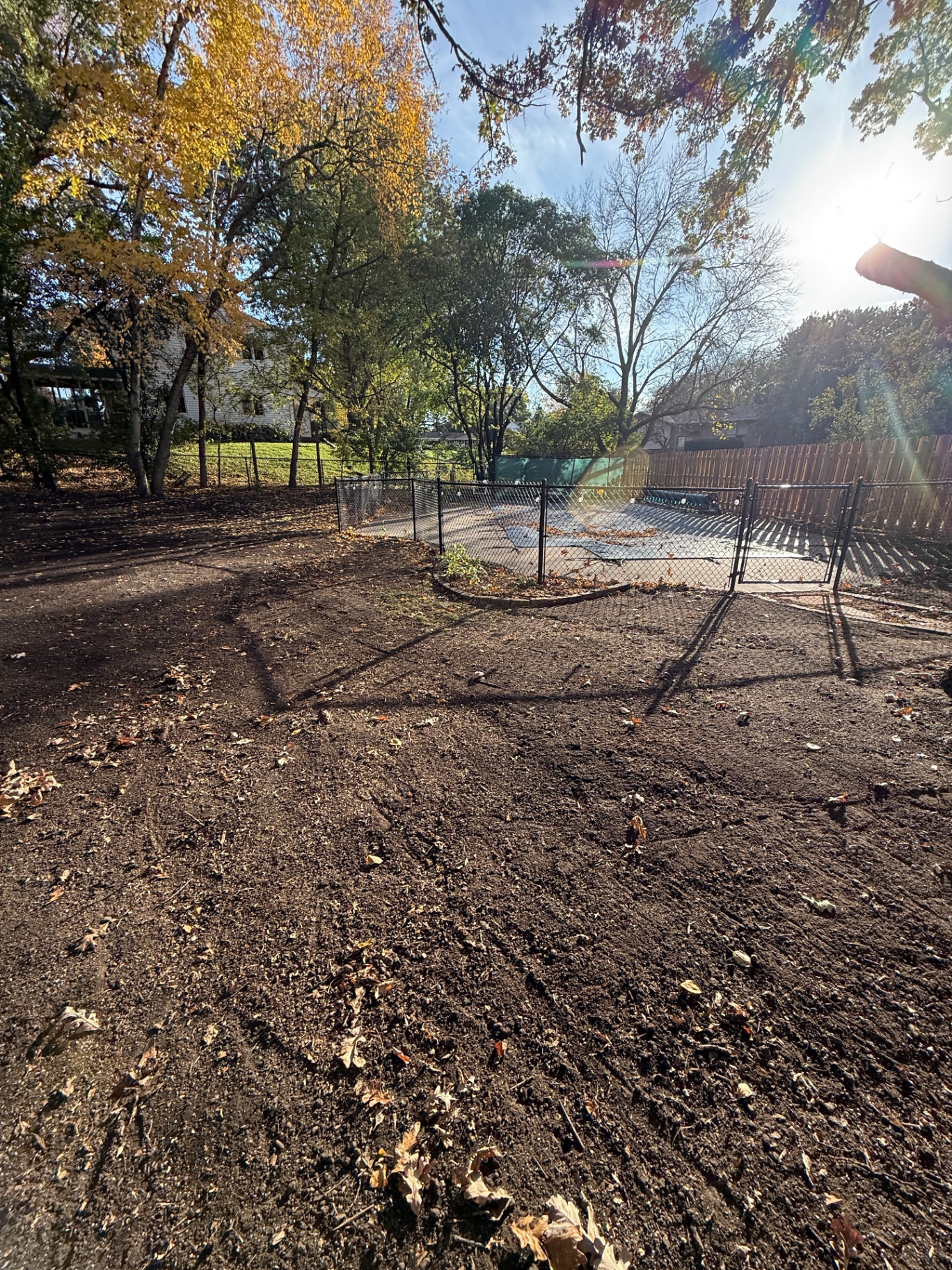 Smooth, regraded backyard with new black-chain-link fence around the future concrete patio pad in Burnsville, MN